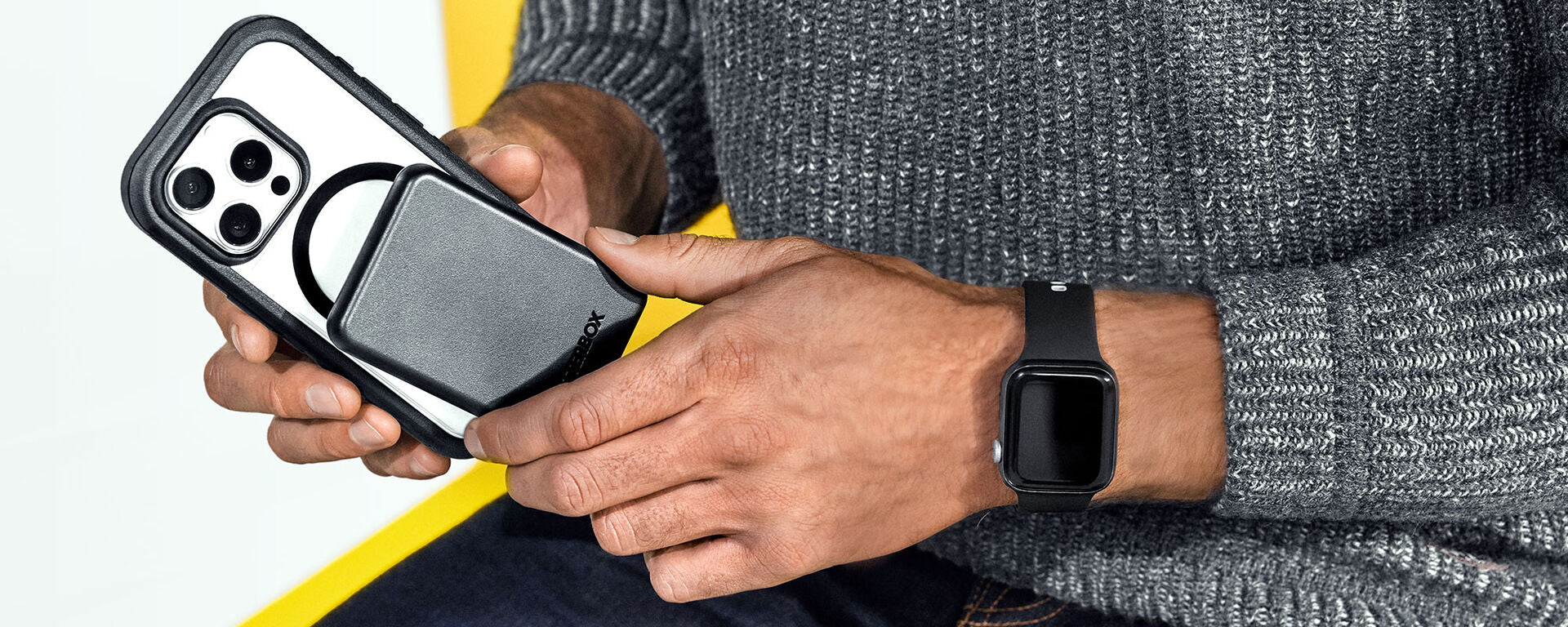 Man attaching OtterBox MagSafe power bank to OtterBox Defender Series Pro XT MagSafe iPhone 16 Pro Max phone case