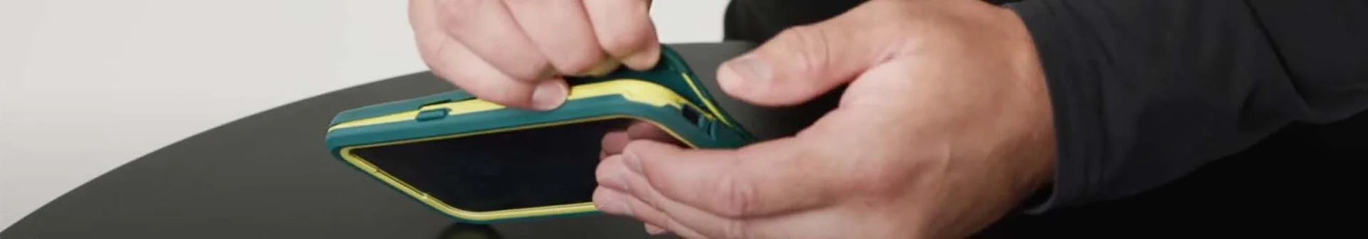 Man removing a dual layer, waterproof OtterBox Fre Series iPhone case