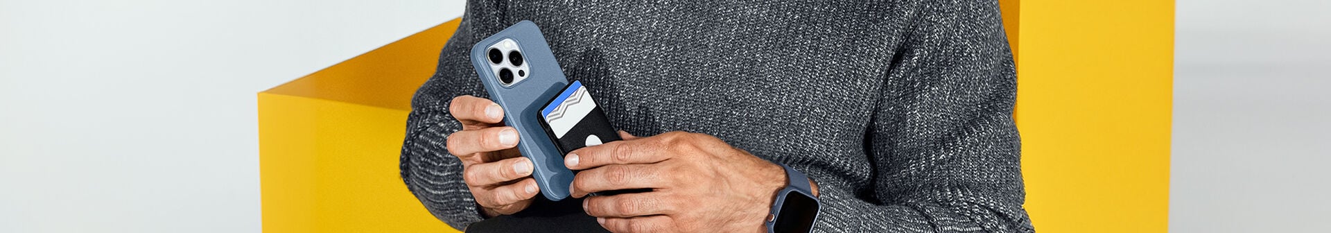 Man attaching black OtterBox MagSafe Wallet on a blue MagSafe OtterBox iPhone case