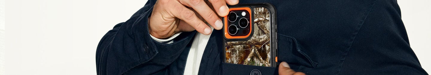 Man placing OtterBox camo print Defender Series for iPhone 16 Pro Max in his pocket