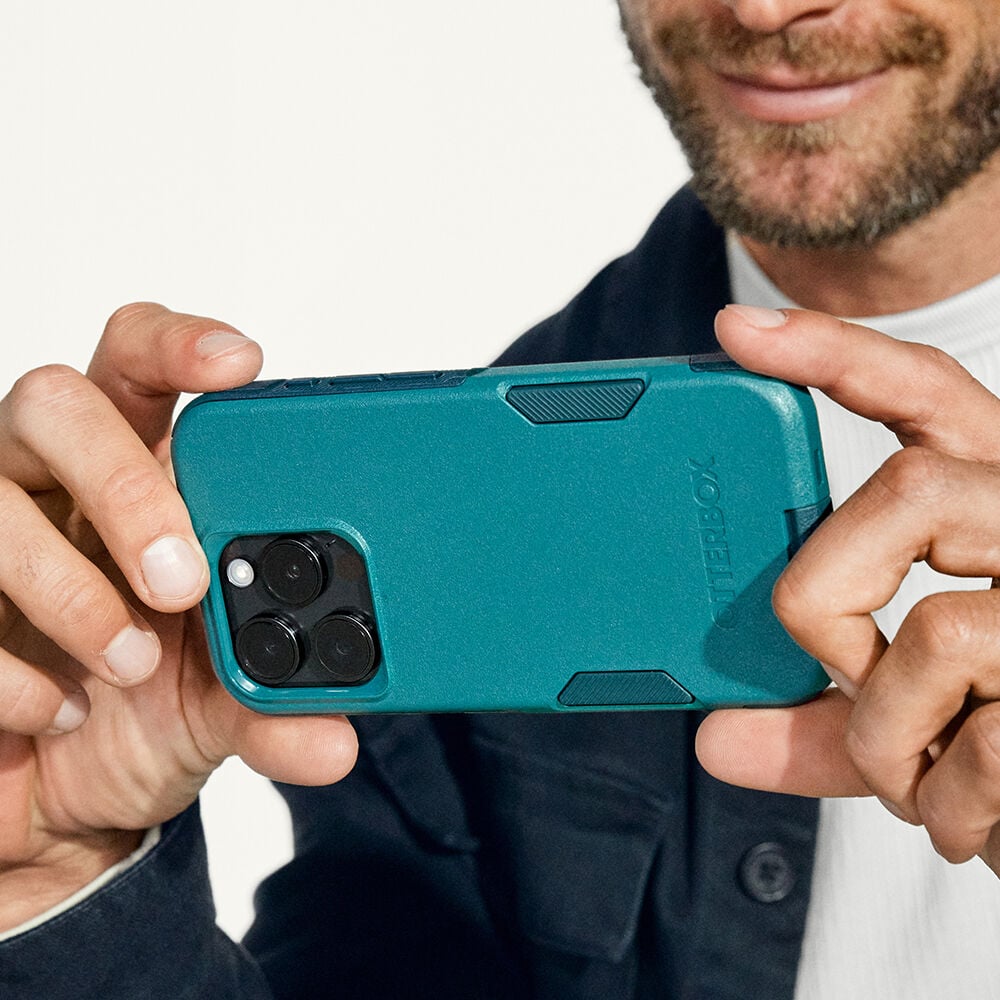 Person holding a teal phone case with a white background