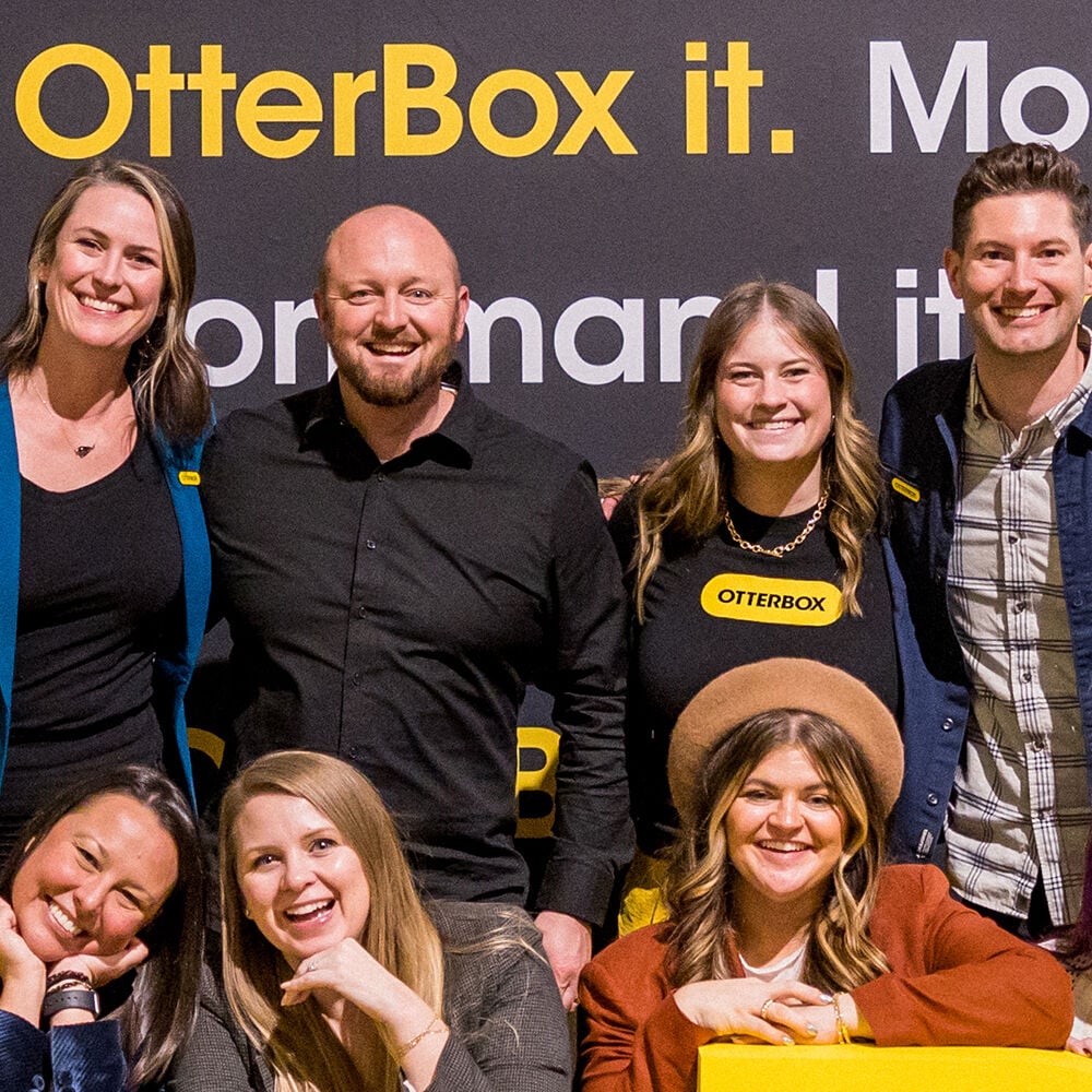 Group of people posing together with OtterBox branding in the background