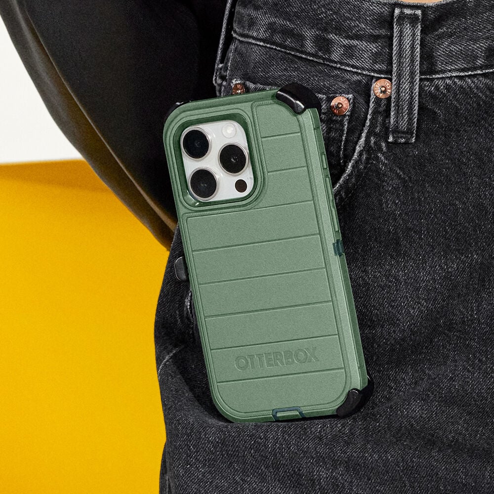 Green OtterBox phone case on a phone held in a pocket against a yellow and black background