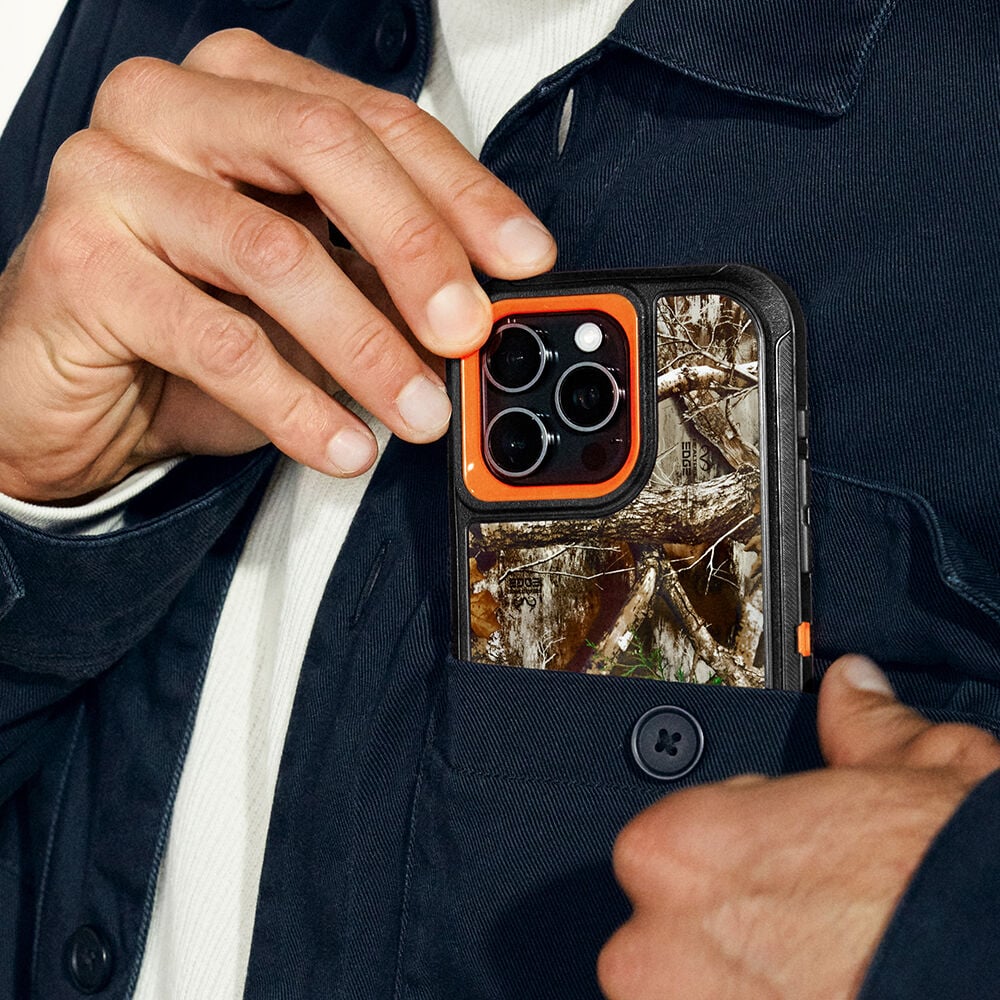 Person holding a phone with a camouflage case against a dark jacket background