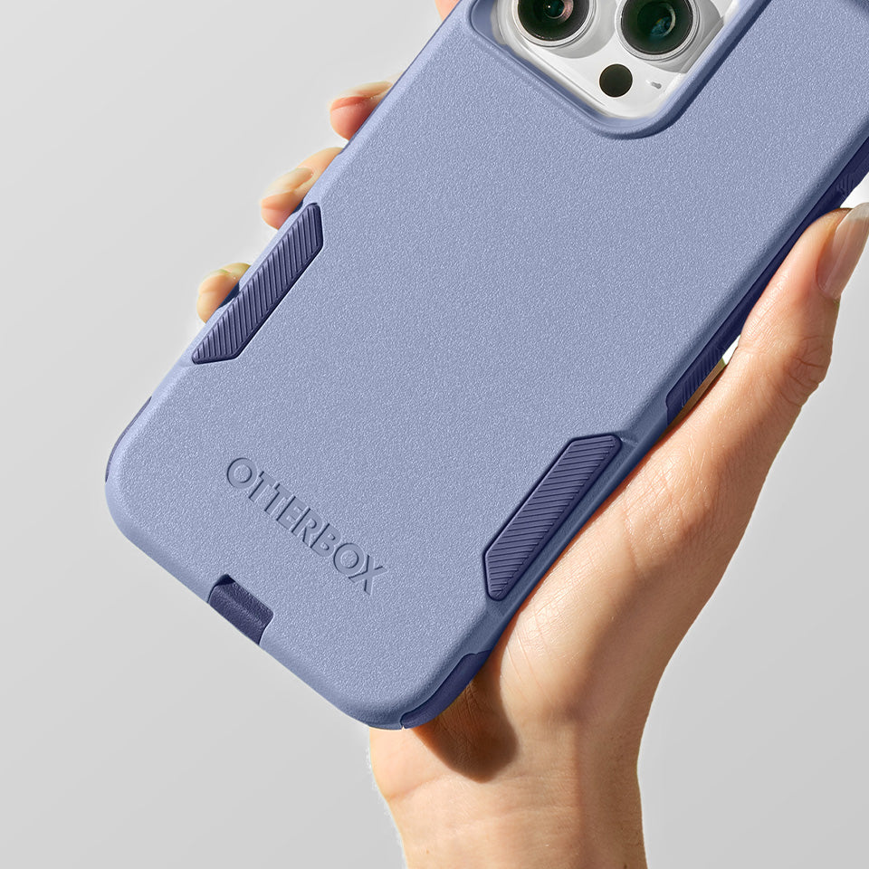 Hand holding a purple OtterBox phone case against a gray background