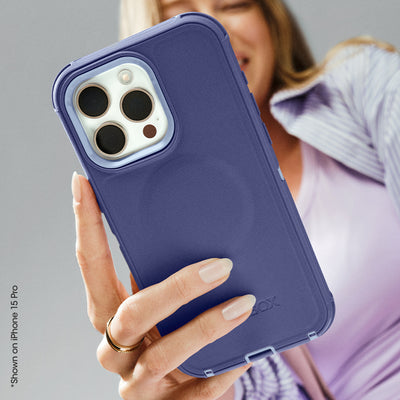 Person holding a phone with a blue case against a neutral background
