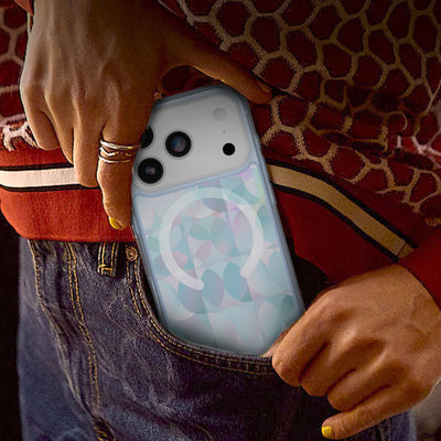 Person placing an iPhone 17 Pro with a colorful Symmetry Series case in their pocket