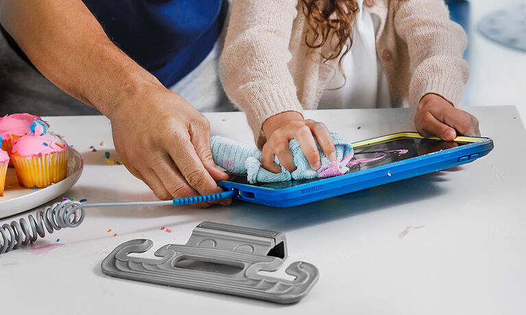 child and parent cleaning frosting off of iPad with blue kids case